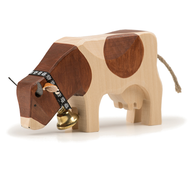 Mucca che mangia un animale di legno di razza Red-Holstein