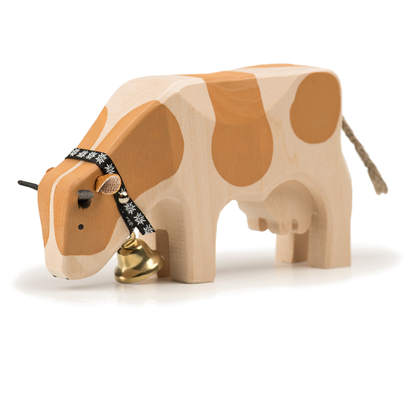 Mucca che mangia un animale di legno Simmental